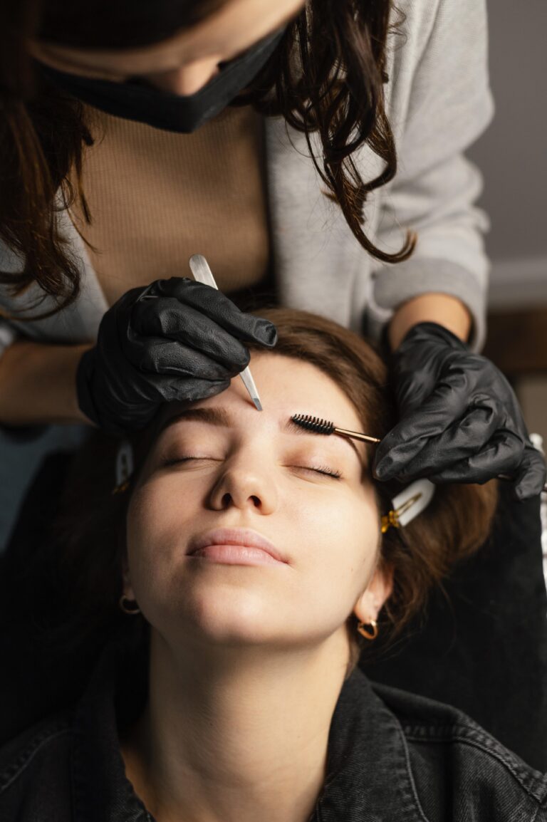 high-angle-female-clinician-doing-eyebrow-treatment-woman